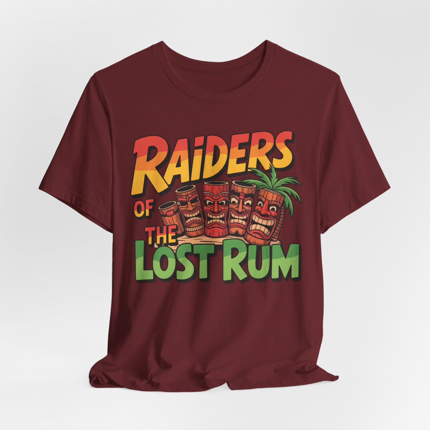 The Tiki T-Shirt - Raiders of the Lost Rum Graphic Tee for Adventure Lovers features bold yellow, orange, and green lettering above tiki mugs and a palm tree on maroon—perfect for summer festivals.