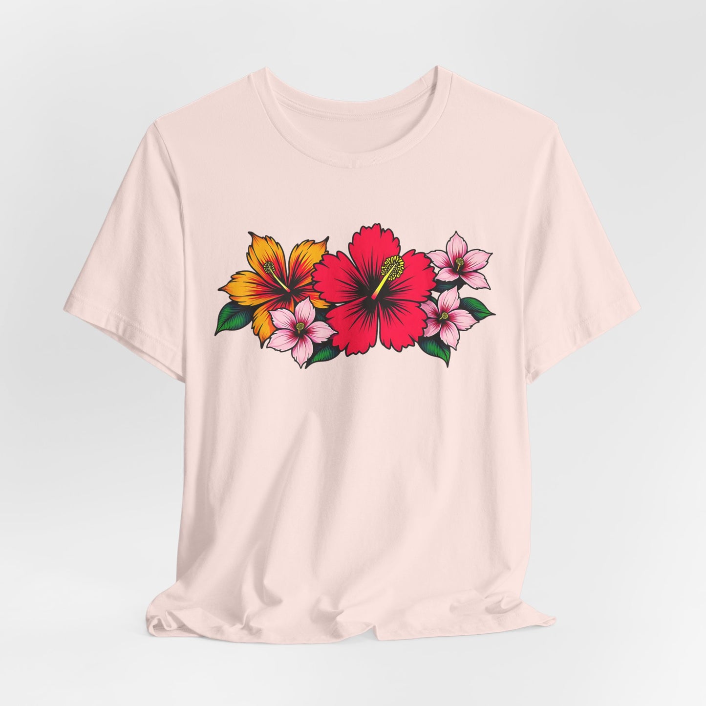 The Tropical Floral Unisex Jersey T-Shirt is light beige with bold floral prints—red and yellow hibiscus and pink flowers with green leaves—ideal for summer outings or beach days.