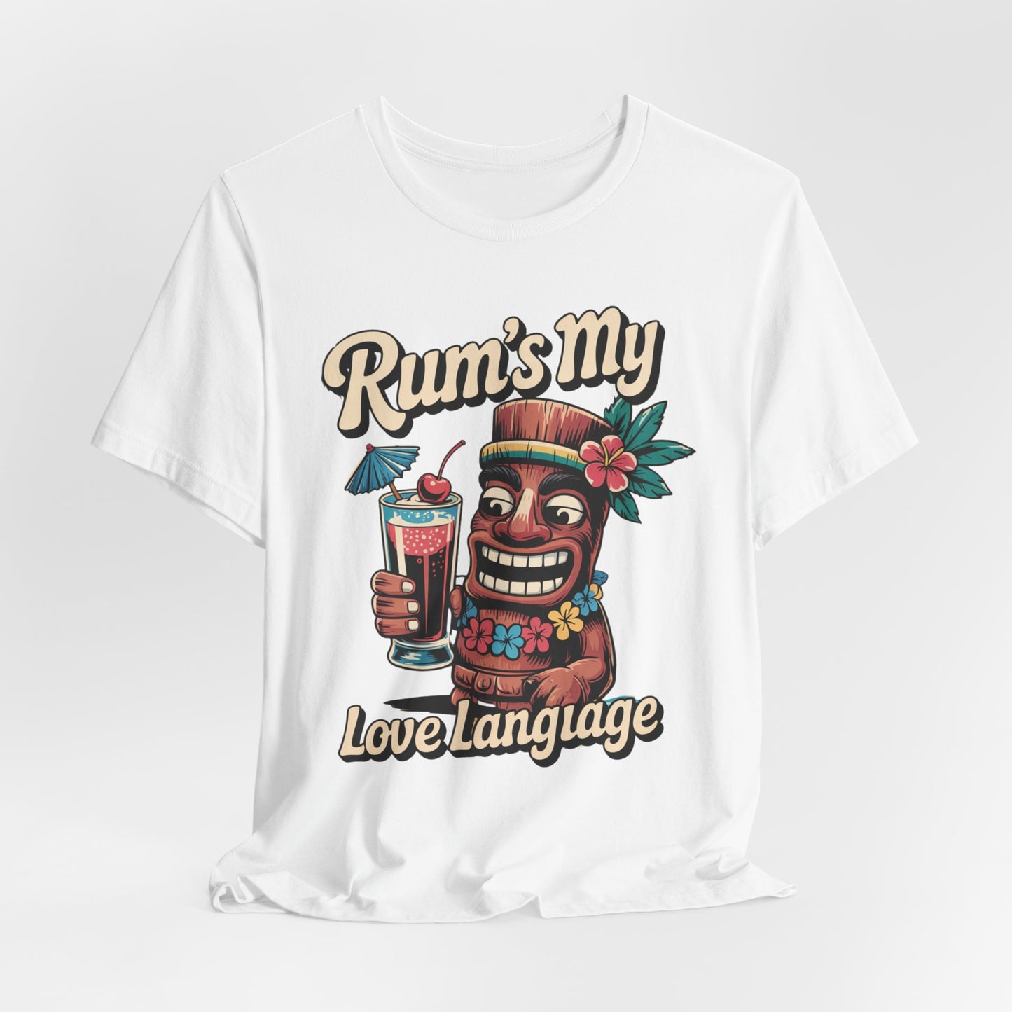 The Tropical Rum Themed Tiki T-Shirt - Rums My Love Language features a smiling tiki with a cocktail, tropical flowers, and playful text that brings bold, unforgettable island vibes to this unisex jersey short sleeve t-shirt.