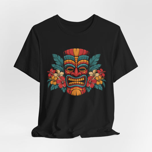 The Tropical Tiki Mask T-Shirt - Unisex Jersey Short Sleeve showcases a vibrant tiki mask in red, yellow, and orange with tropical flowers and green leaves—ideal for expressing a bold, tropical style.
