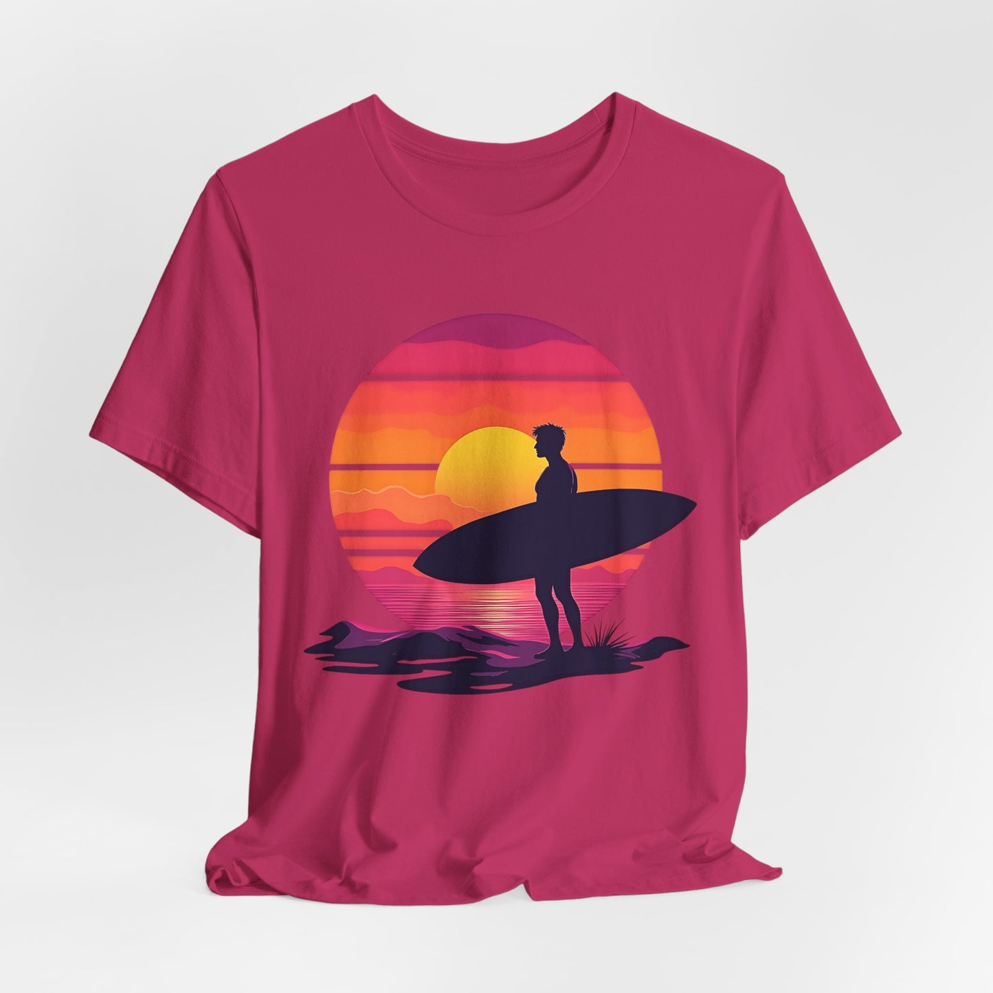 The Sunset Surfing Unisex Jersey T-Shirt features a surfer with a surfboard on a beach at sunset with ocean waves—ideal for beach lovers. Printed in vibrant colors using Direct-to-Garment (DTG) printing.