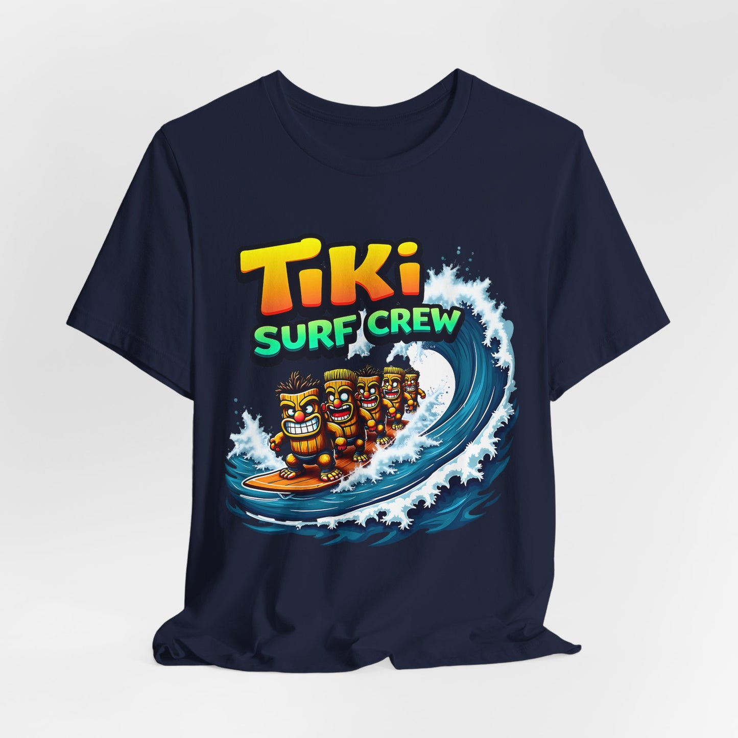 The Tiki Surf Crew Graphic Tiki T-Shirt is a fun unisex jersey short sleeve shirt featuring three cartoon tikis surfing and vibrant TIKI SURF CREW text—ideal for surf lovers and beach enthusiasts.