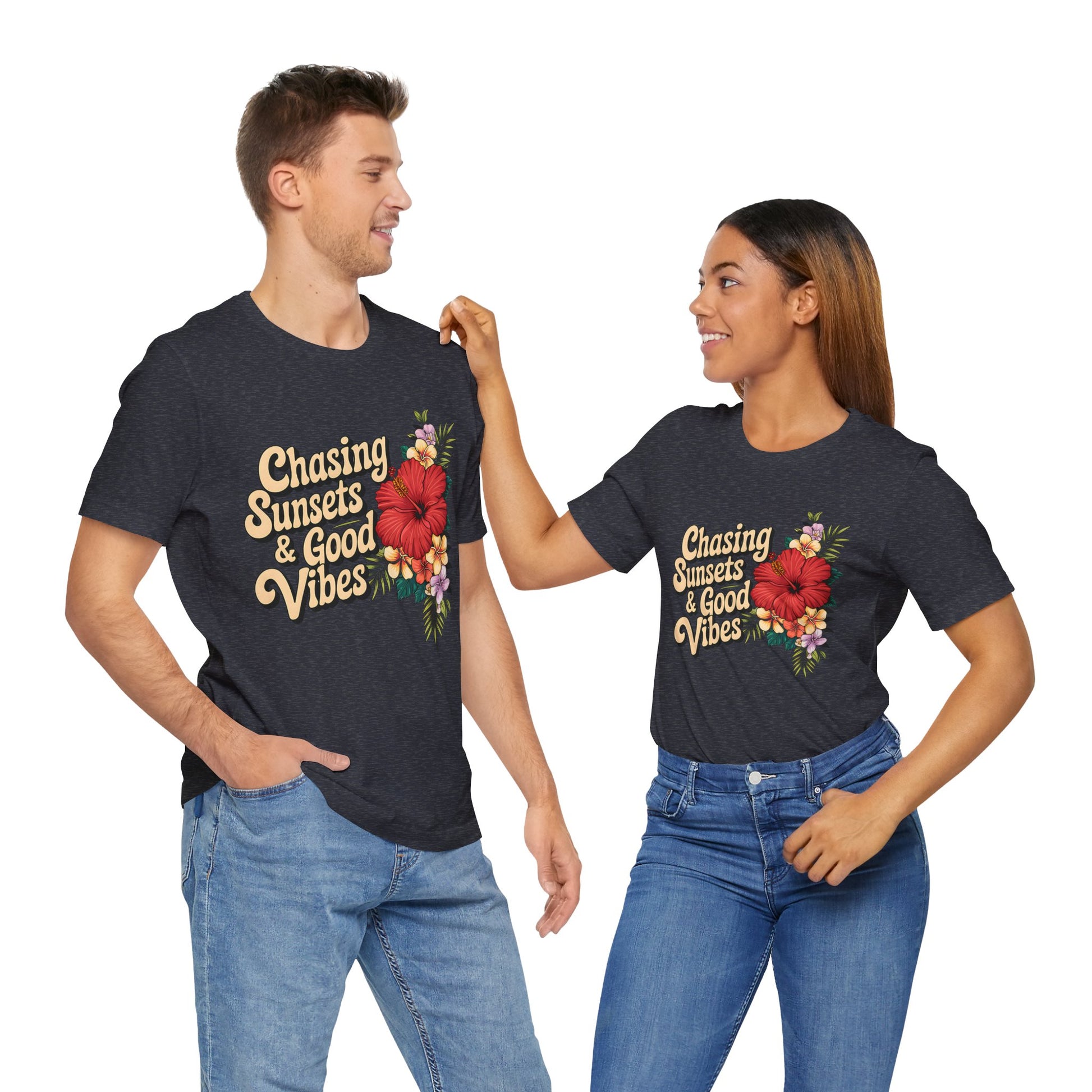 A smiling man and woman, hands in their jeans pockets, wear matching Chasing Sunsets & Good Vibes Tee—Unisex Jersey Short Sleeve Shirts perfect for summer adventures with vibrant floral designs.