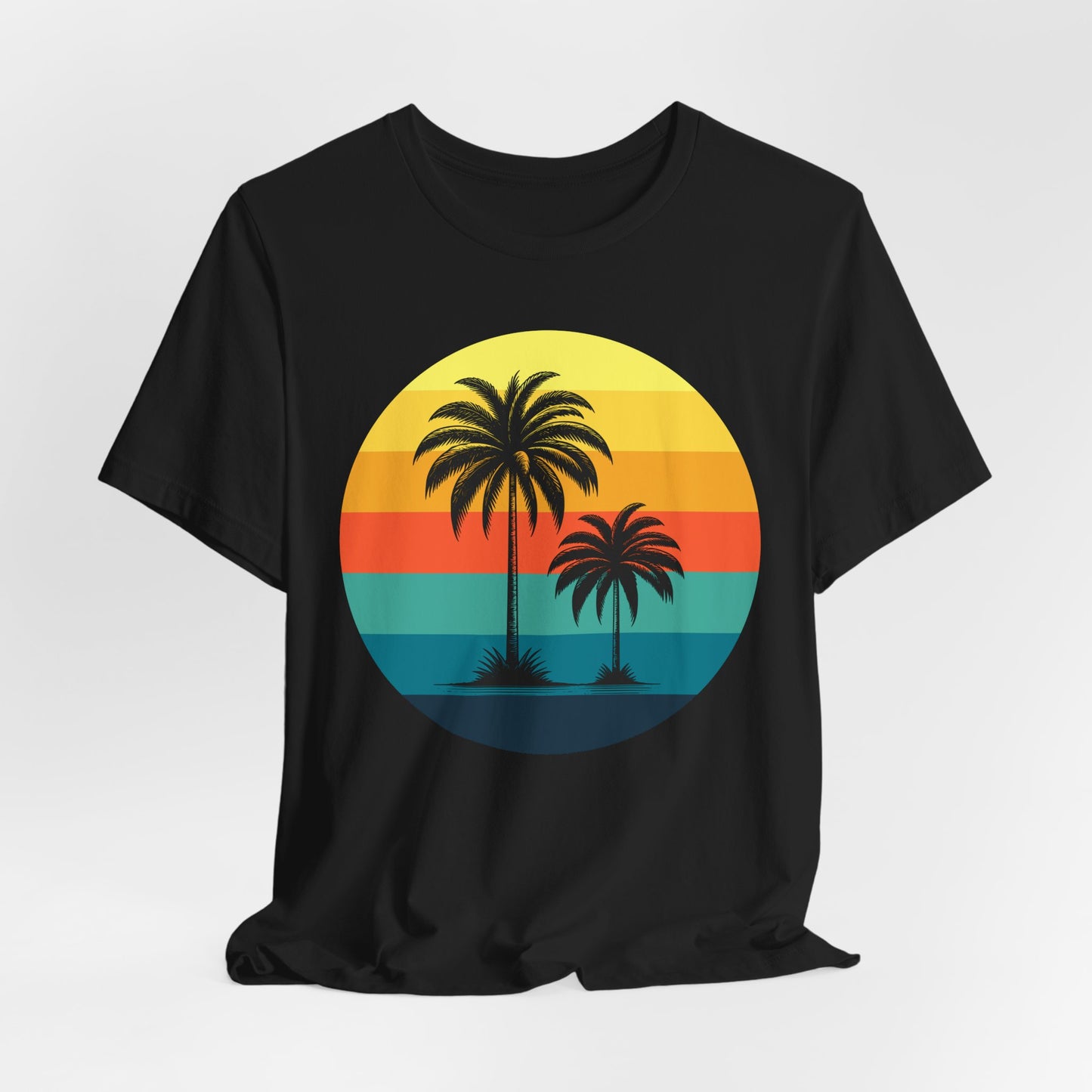 The Sunset Palm Trees Unisex Jersey T-Shirt - Vibrant Beach Vibe features a black tee with a circular graphic of two palm trees over a retro striped sunset in yellow, orange, red, and teal—ideal for summer holidays and tropical events.