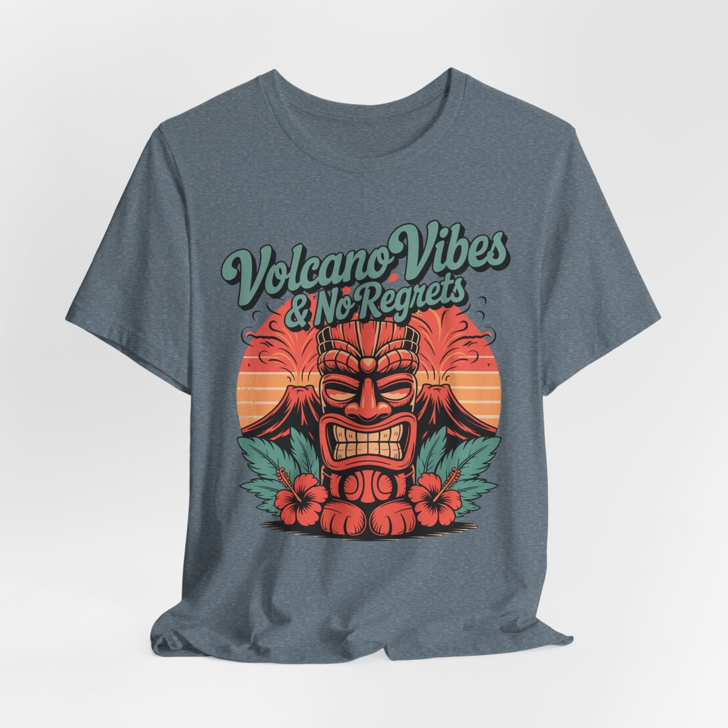 The Volcano Vibes and No Regrets Unisex Tiki T-Shirt is a gray short sleeve tee with a colorful tiki face, hibiscus flowers, an erupting volcano, and retro text—ideal for summer adventures.