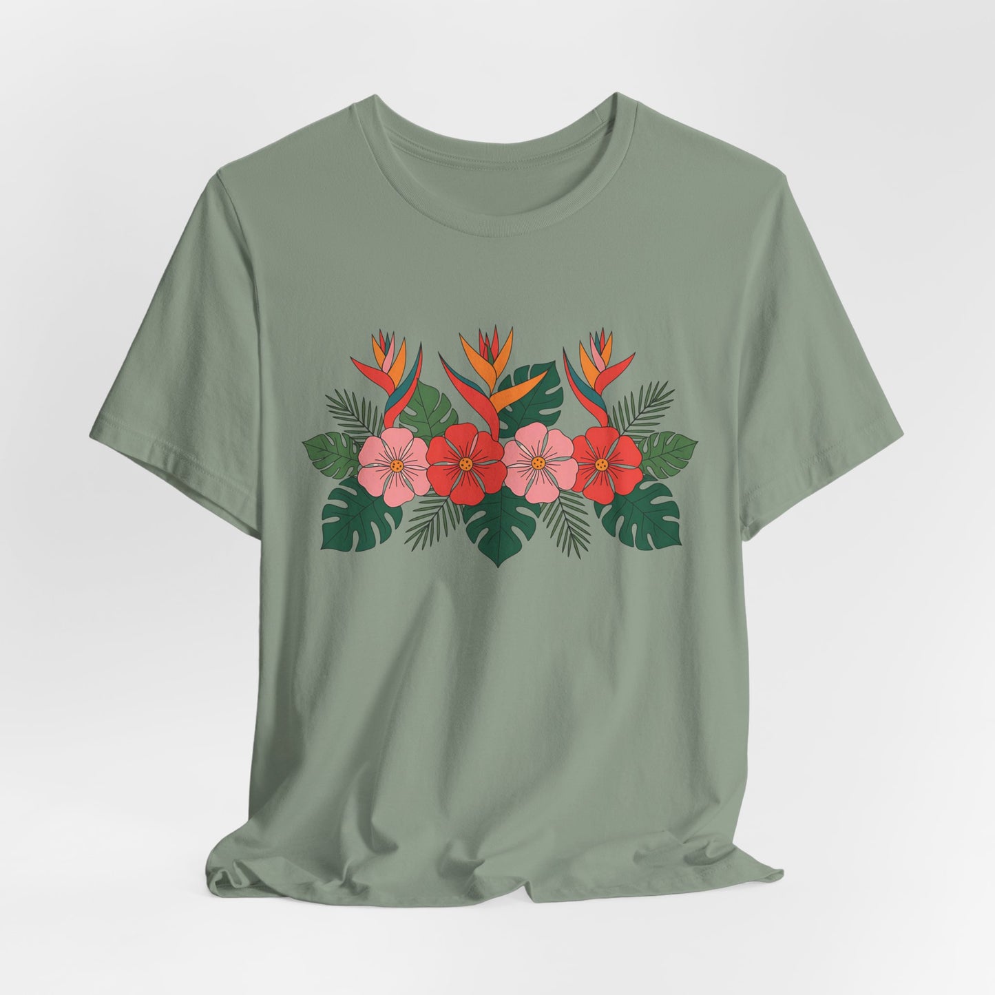 The Tropical Floral Unisex T-Shirt – Perfect for Summer Celebrations features a vibrant print with pink and red flowers, orange bird-of-paradise blooms, and green leaves on light green, made from breathable fabric for all-day comfort.