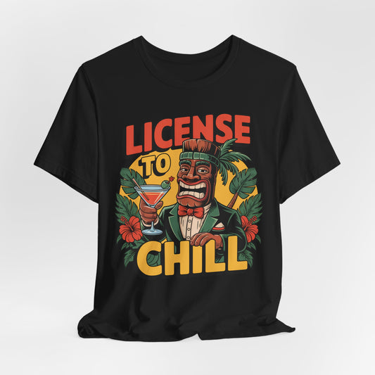 The T-Shirt - License to Chill Tropical Graphic Tiki T-Shirt features a cartoon tiki in a suit with a cocktail, tropical leaves, red flowers, and bold LICENSE TO CHILL text—an ideal playful gift for summer barbecues.