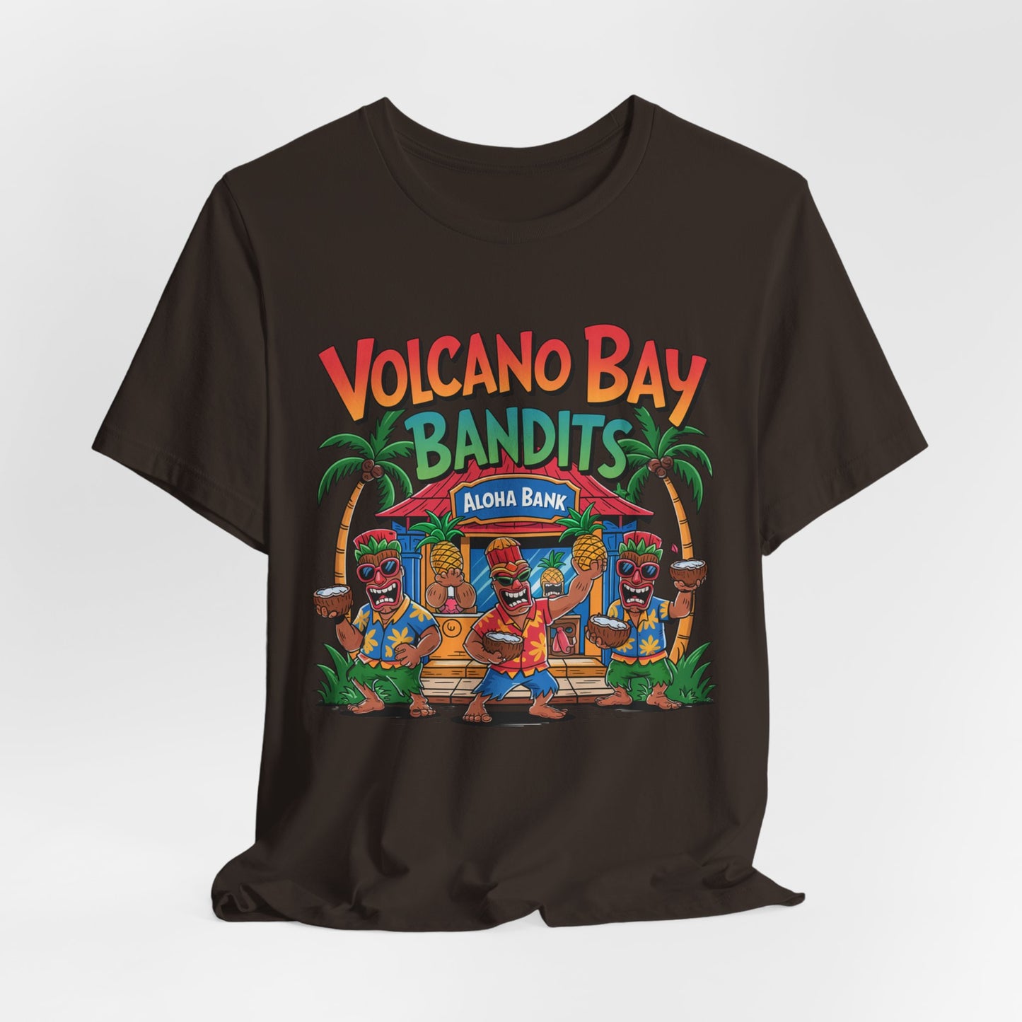 The Volcano Bay Bandits Graphic Tiki T-Shirt is a black unisex short sleeve shirt with a vibrant cartoon of three tiki dancers by a tropical hut, palm trees, and the text Volcano Bay Bandits and Aloha Bank—great for casual or adventure wear.