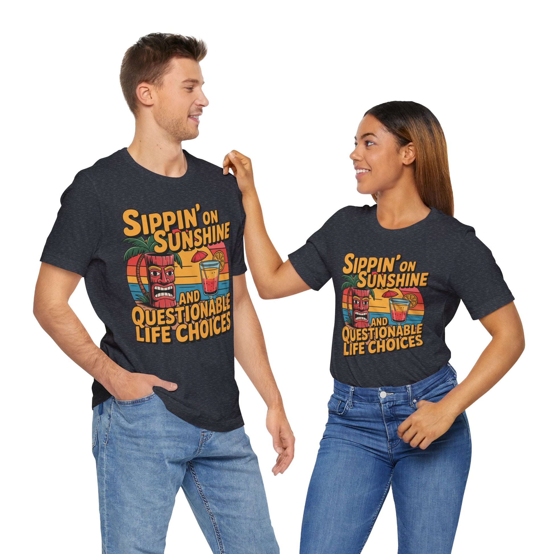 A man and woman smile, both wearing Sippin on Sunshine Tiki T-Shirts—fun unisex jersey shirts with vibrant tiki, sunglasses, and rainbows. Their cotton tees say “Sippin’ on Sunshine and Questionable Life Choices”—perfect for beach lovers.