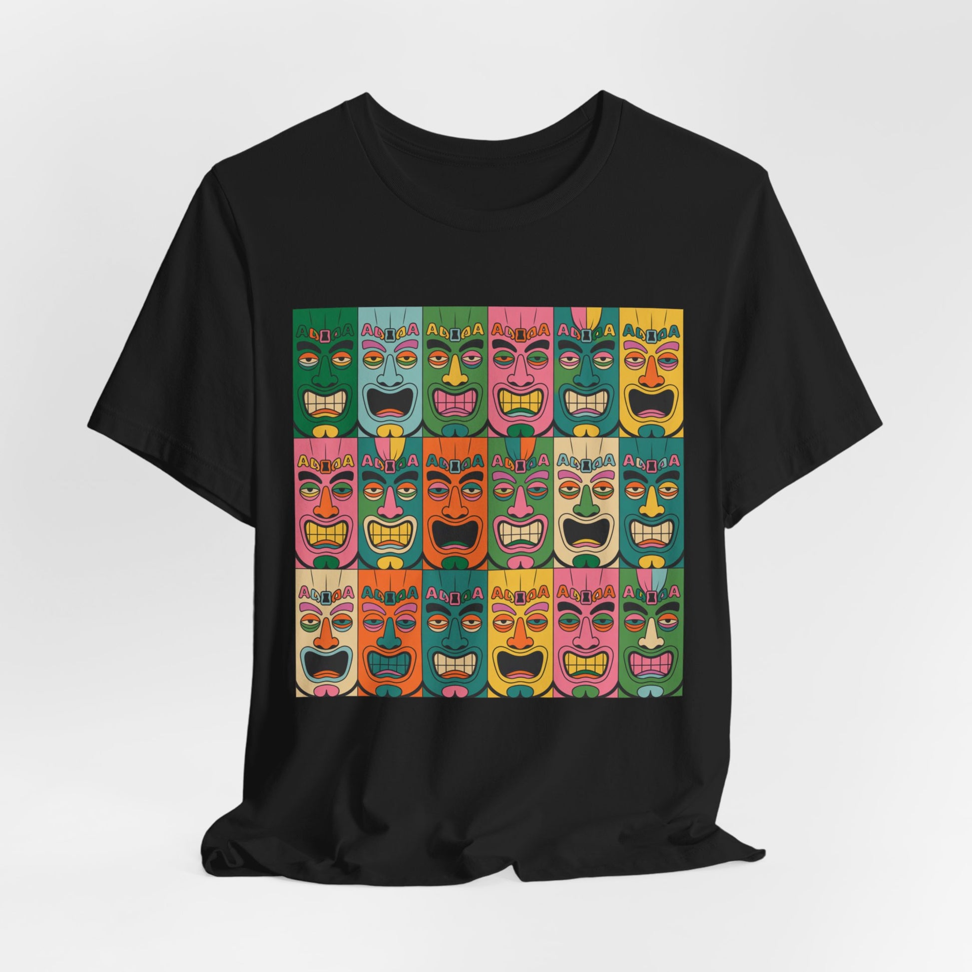 The Vibrant Tribal Mask Unisex Tiki T-Shirt is a black tee with a colorful grid of cartoonish tiki faces in red, yellow, pink, green, blue, and orange. Eco-friendly manufacturing ensures sustainable style.