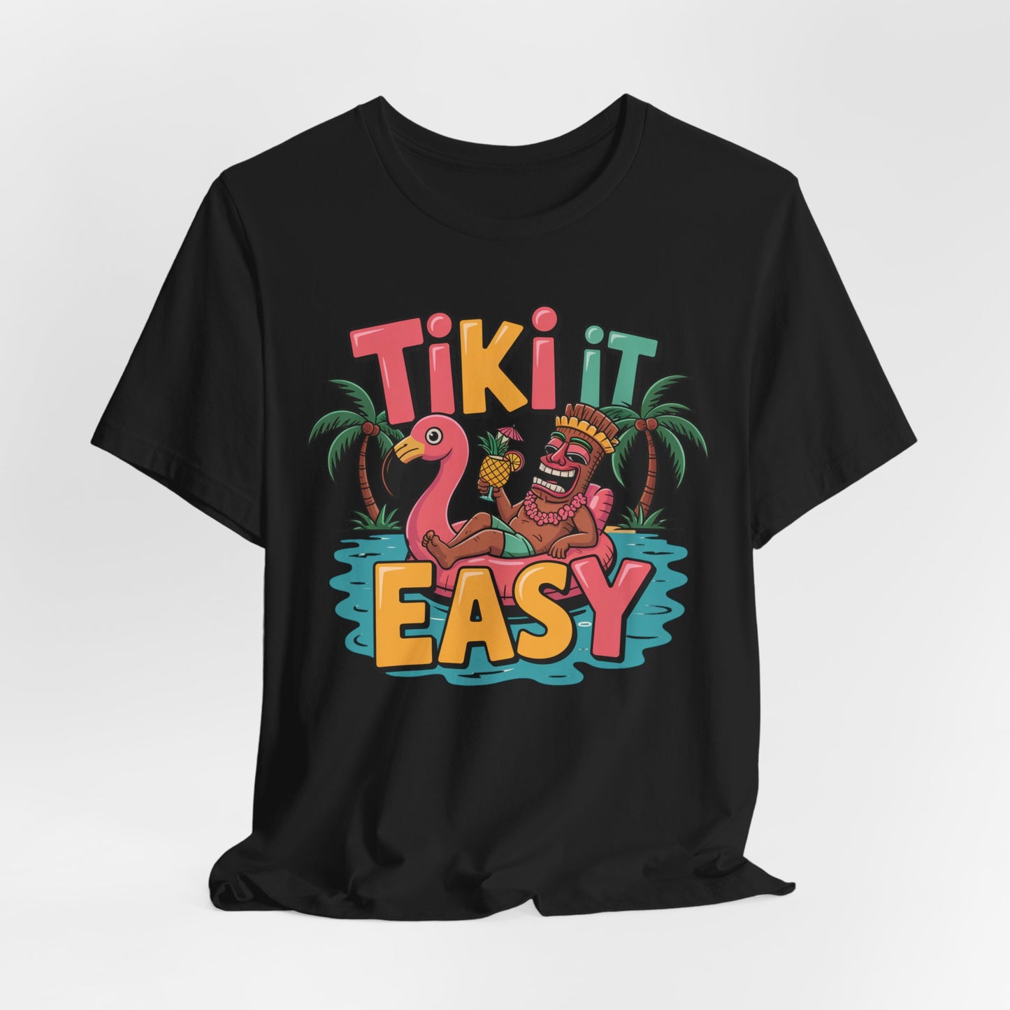 The Tiki It Easy Unisex Short Sleeve Tiki T-Shirt features a cheerful tiki on a pink flamingo float, palm trees, and the phrase Tiki It Easy—a perfect pick for tropical beach vibes.