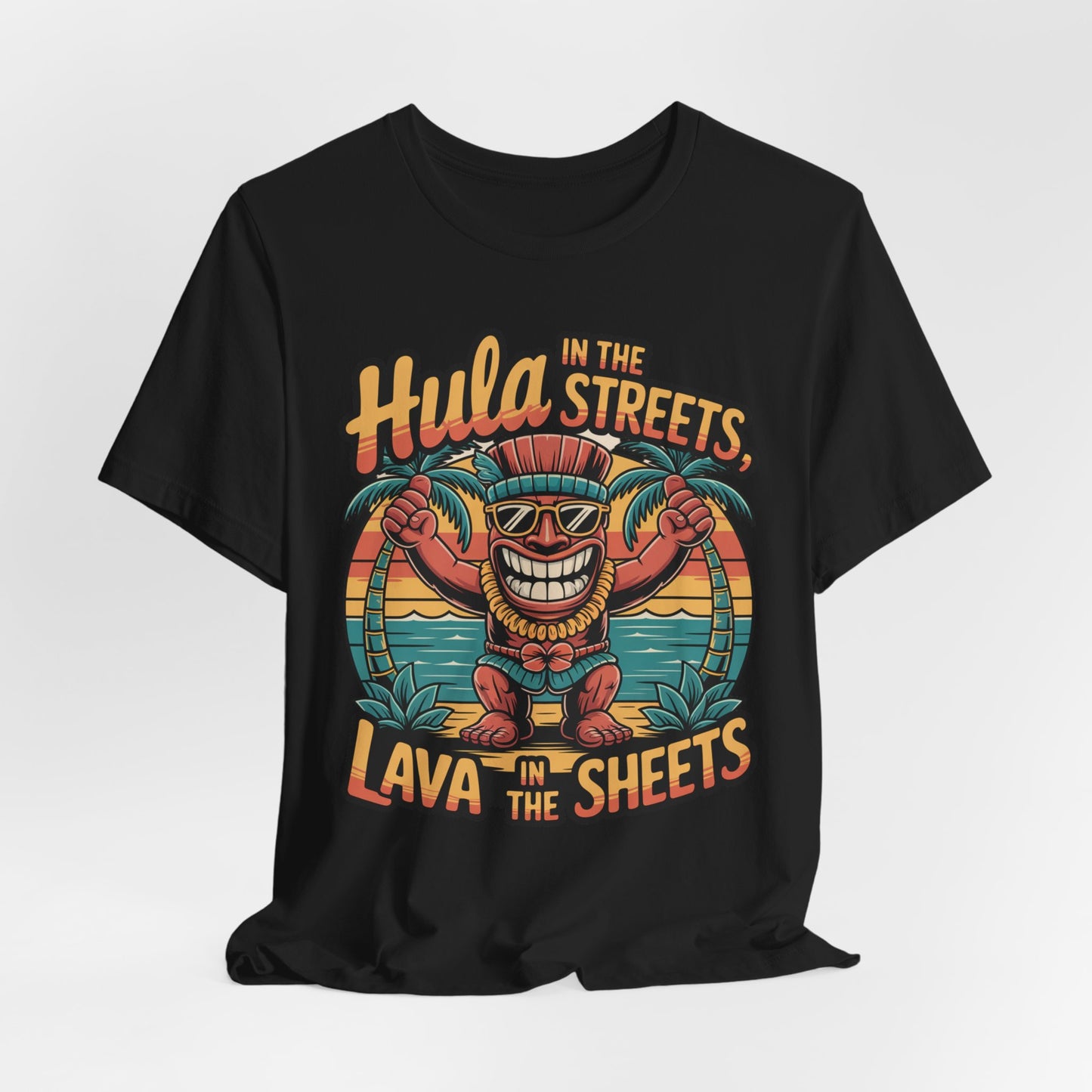 The Hula in the Streets Short Sleeve Tiki T-Shirt is a black unisex tee featuring a smiling cartoon tiki with sunglasses, dancing amid palm trees, and the phrase “Hula in the streets, Lava in the sheets.” Great for summer celebrations.