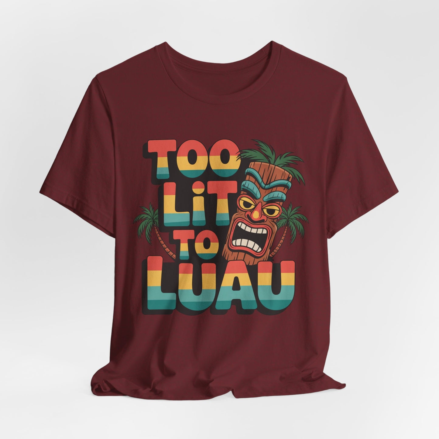 The Too Lit to Luau Unisex Jersey Short Sleeve Tiki T-Shirt features a vibrant tiki face, palm trees, and colorful text—perfect for tropical summer gatherings and tiki parties.