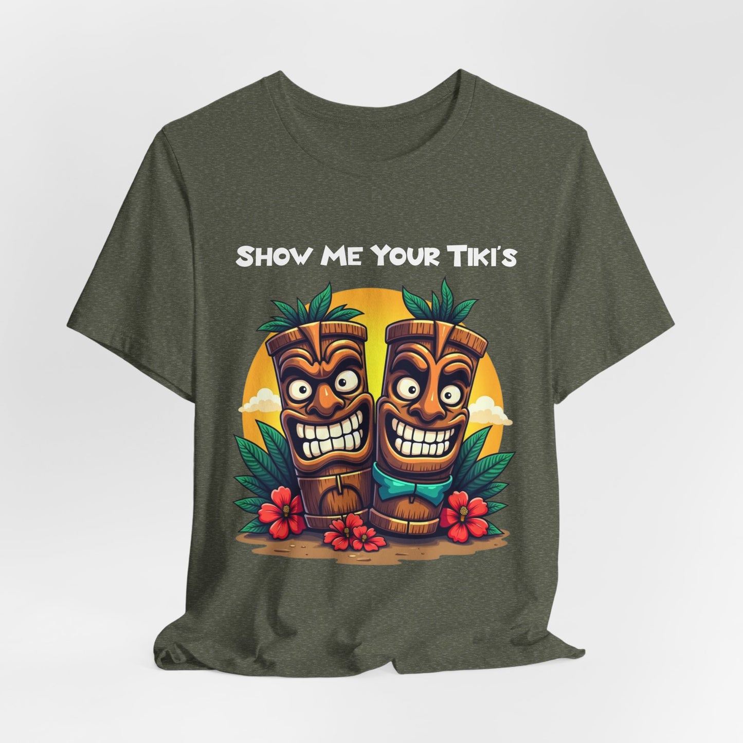 The Tiki Fun Unisex Jersey Short Sleeve Tiki T-Shirt features two cartoon tikis, tropical leaves, red hibiscus flowers, and Show Me Your Tikis text. Made from soft Airlume cotton for comfort and style.