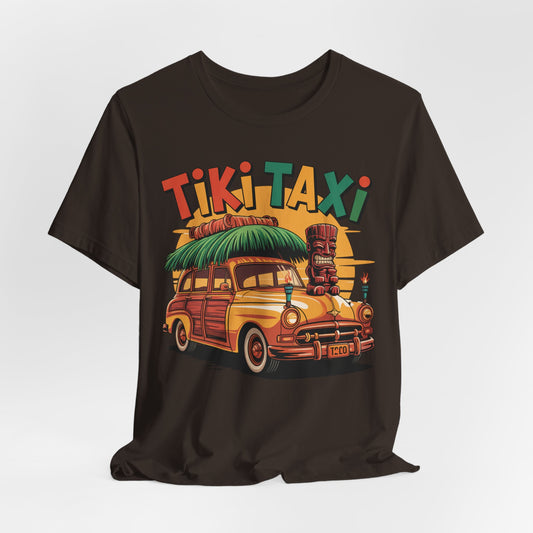 The Tiki Taxi Graphic Tiki T-Shirt for Summer Vibes is a black unisex jersey featuring a vibrant yellow vintage car, surfboards, tiki statue, palm trees, and bold “Tiki Taxi” text—ideal for anyone who loves the beach or tropical style.
