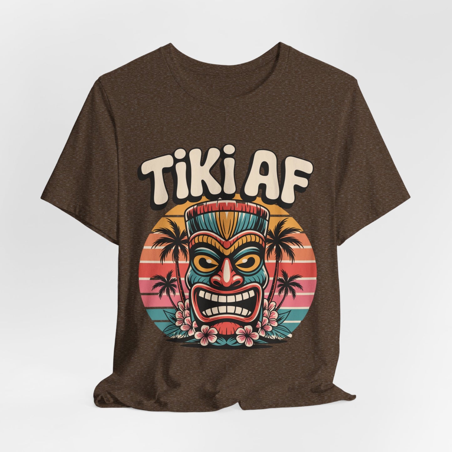 The Tiki AF Unisex Jersey Short Sleeve Tiki T-Shirt features a colorful tiki mask, tropical flowers, and sunset palms—perfect for beach lovers and anyone who loves bold tropical vibes.