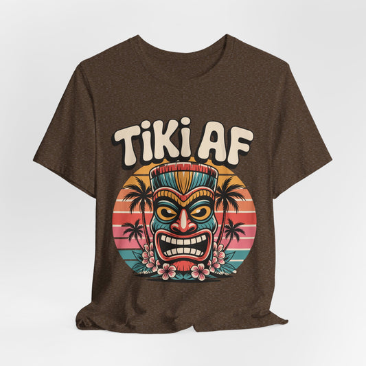 The Tiki AF Unisex Jersey Short Sleeve Tiki T-Shirt features a colorful tiki mask, tropical flowers, and sunset palms—perfect for beach lovers and anyone who loves bold tropical vibes.