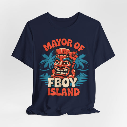 The Mayor of FBOY Island Short Sleeve Tiki T-Shirt is a navy blue unisex tee with a cartoon tiki face, flower, tropical leaves, and MAYOR OF FBOY ISLAND in bold orange and cream—perfect for fun summer vibes.