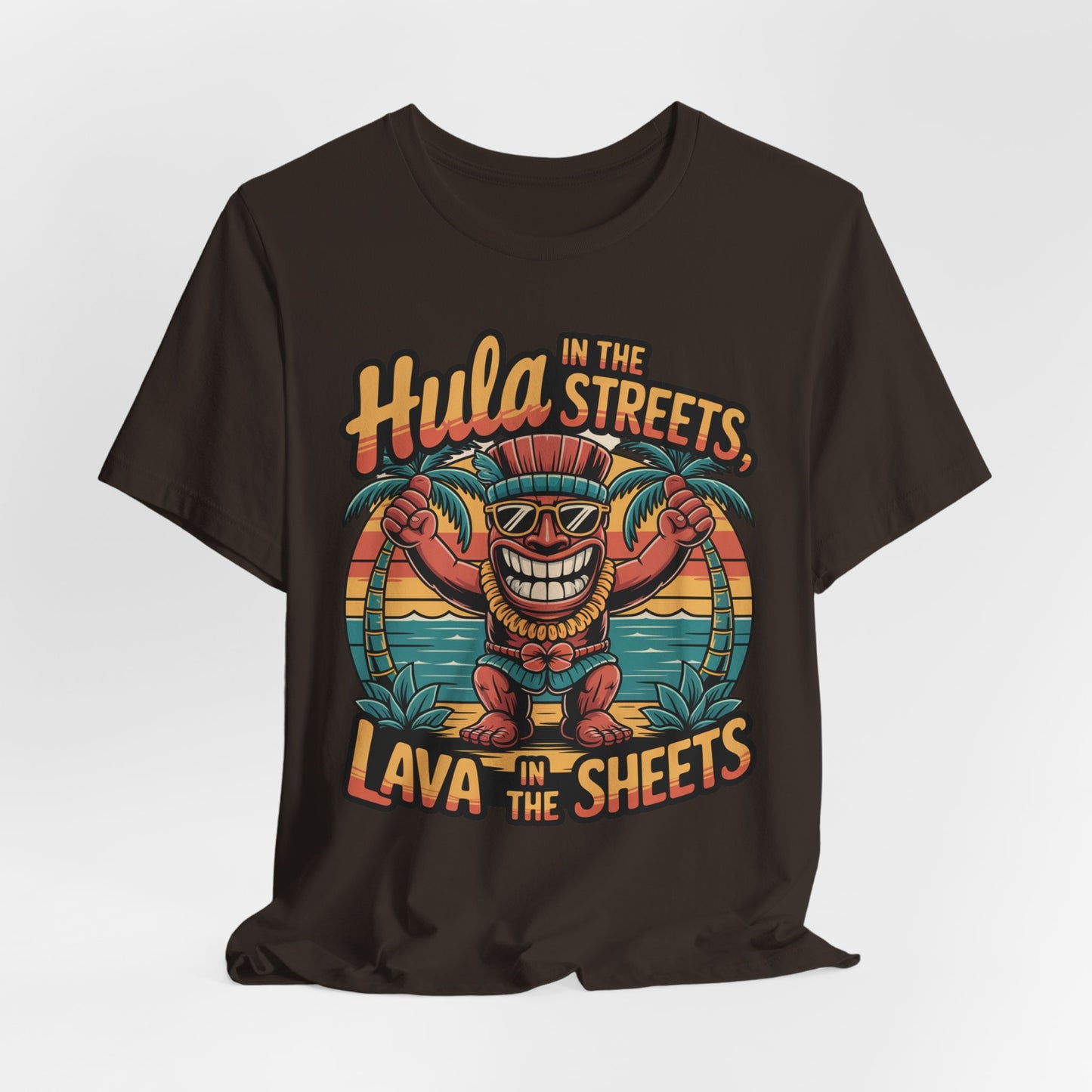 The Hula in the Streets Short Sleeve Tiki T-Shirt is a unisex jersey featuring a cartoon tiki in shades, palm trees, sunset, and ocean, plus playful text: Hula in the streets, lava in the sheets. Perfect for tropical summer celebrations!.