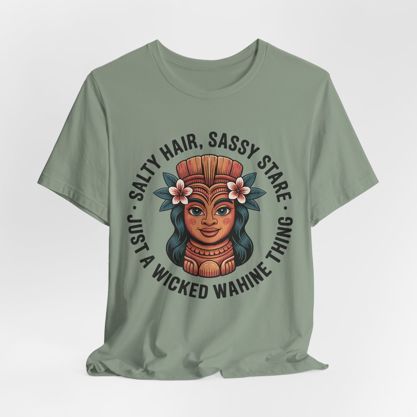 The Wicked Wahine Graphic T-Shirt - Salty Hair, Sassy Stare T-Shirt is a green unisex tee featuring an illustrated wahine with a headdress and flowers, plus the phrase: “Salty Hair, Sassy Stare, Just a Wicked Wahine Thing.” Perfect for nature or beach lovers.