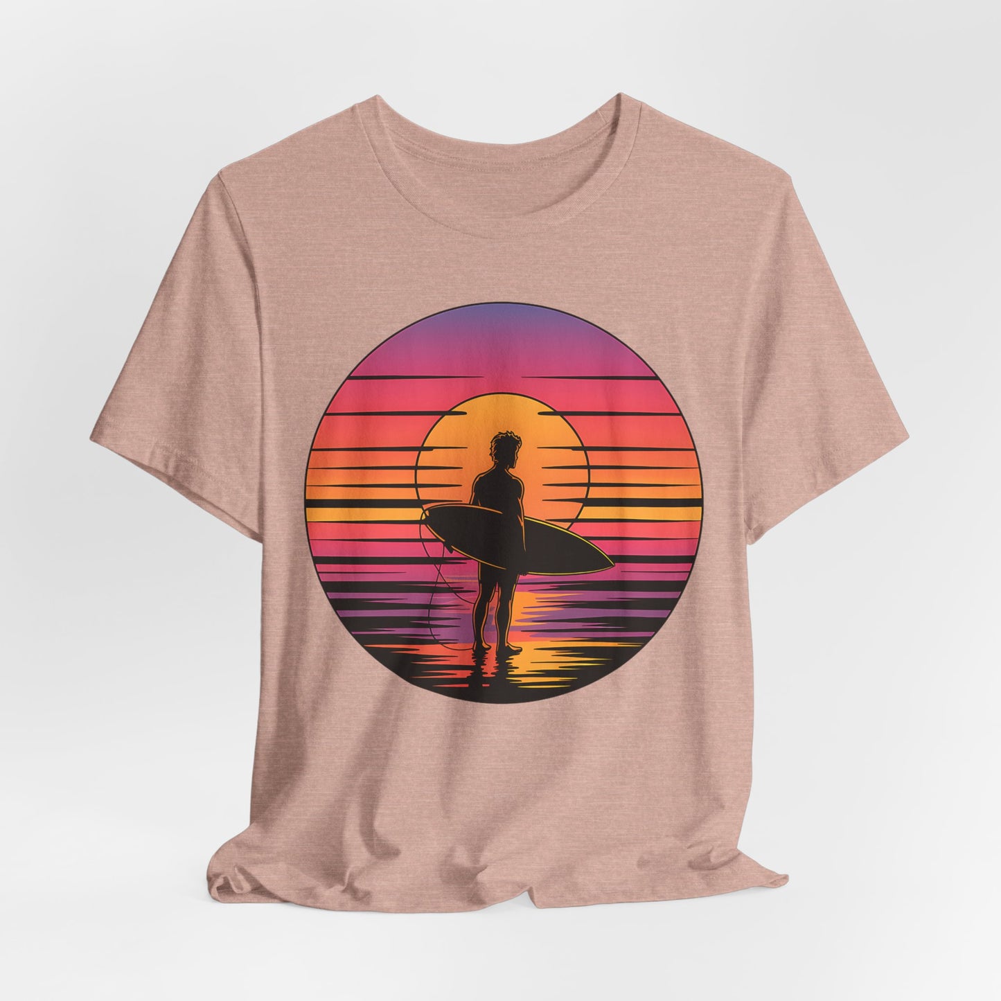 The Retro Surfing Unisex Jersey T-Shirt - Sunset Vibes features a circular surfer-at-sunset graphic in orange, pink, and purple tones. Made from soft Airlume combed and ring-spun cotton for a vibrant beach-inspired look.