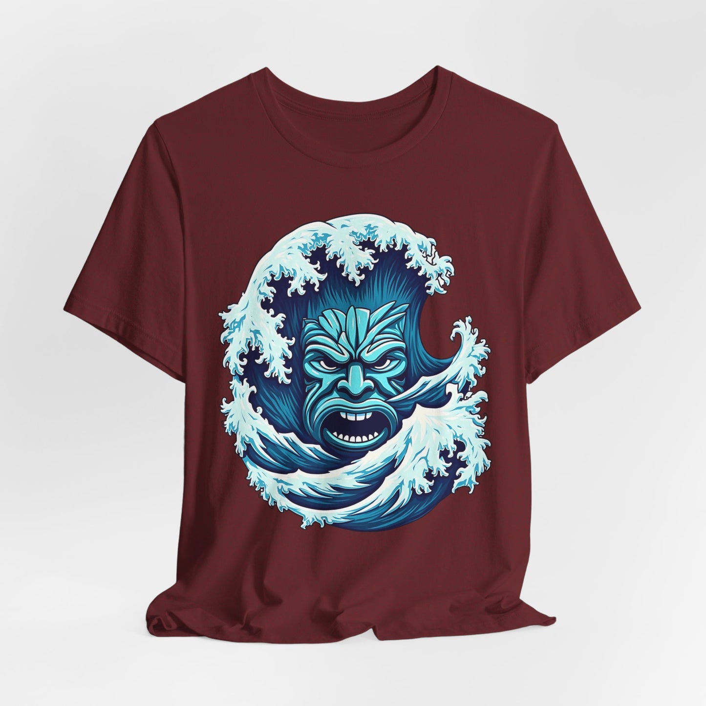The Ocean Wave Tiki- Adventure Vibes Unisex Jersey T-Shirt, made from soft Airlume cotton, features a bold blue wave with a fierce face in tribal style—ideal for beach lovers.