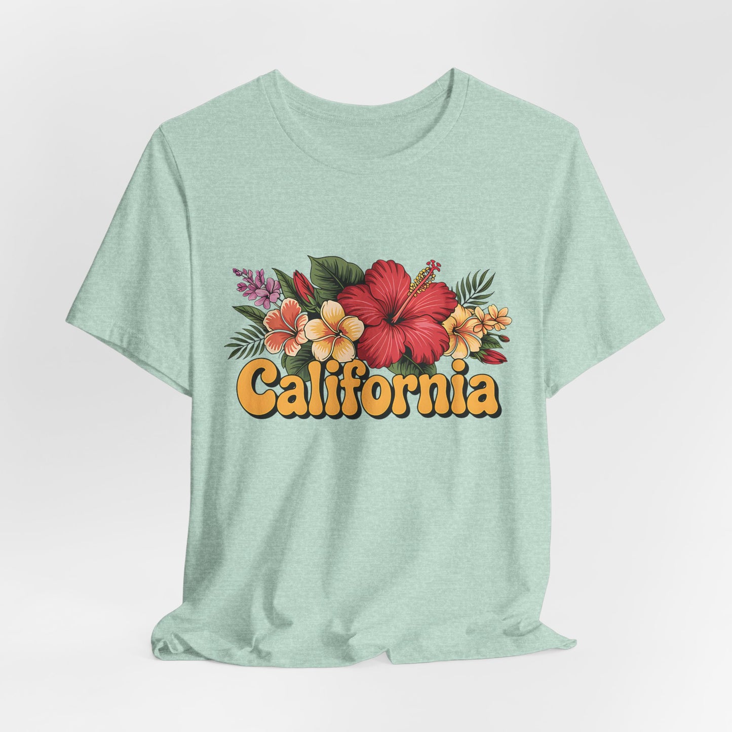 The California Floral Graphic T-Shirt Summer Vibes Unisex T-Shirt features vibrant tropical flowers and leaves above “California” in bold yellow retro letters, displayed on a light green tee against a plain white background.