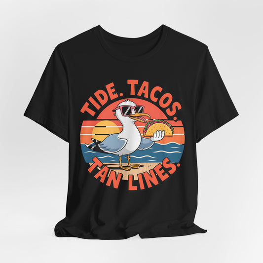 The Beach Vibes Unisex T-Shirt – Tide, Tacos, Tan Lines Summer Shirt features a seagull in sunglasses holding a taco on the beach at sunset—perfect for ultimate summer beach style.