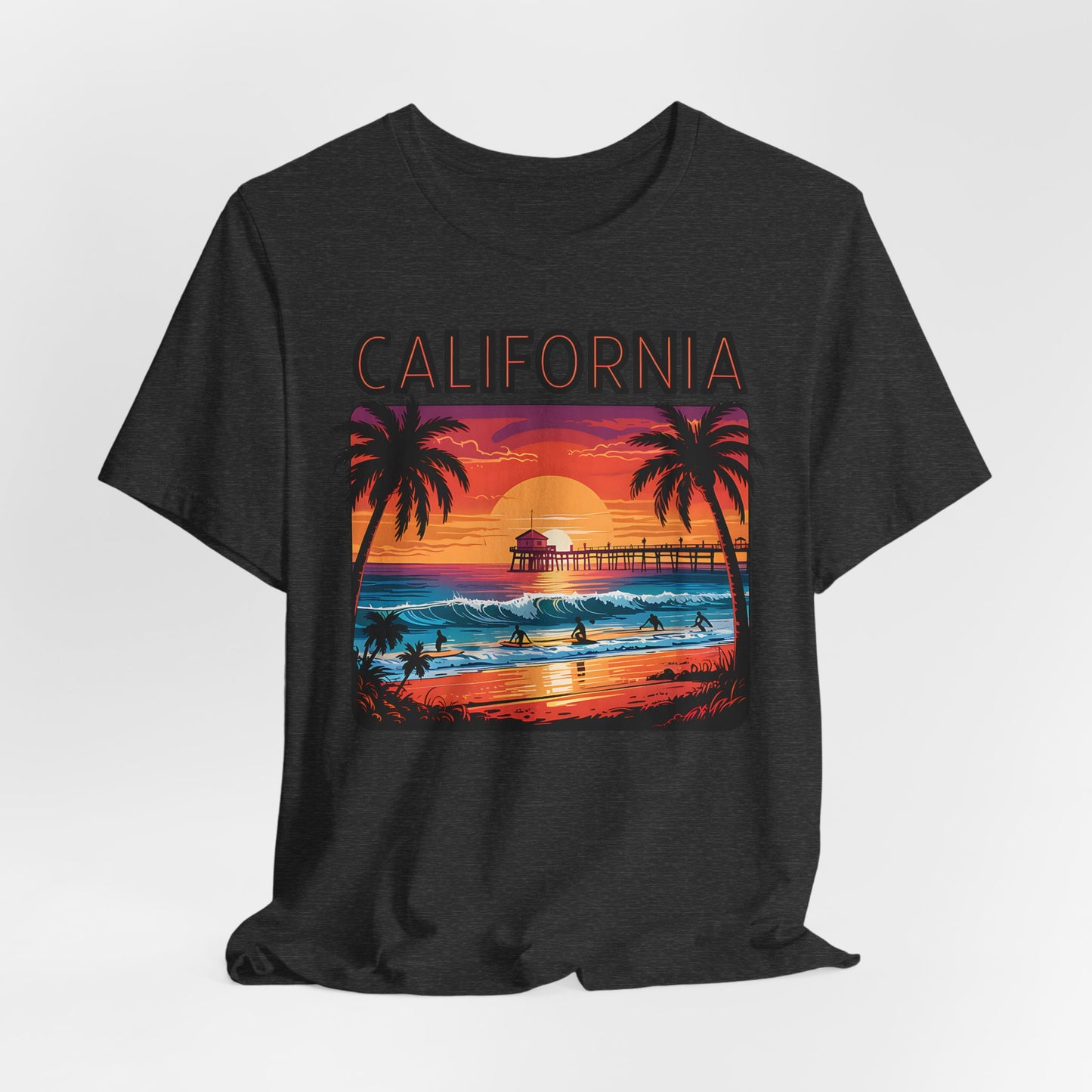The California Sunset Unisex Jersey T-Shirt - Vintage Beach Vibe features a vibrant sunset beach scene with palm trees, surfers, a pier, and bold California lettering—perfect for beach lovers and casual style fans.