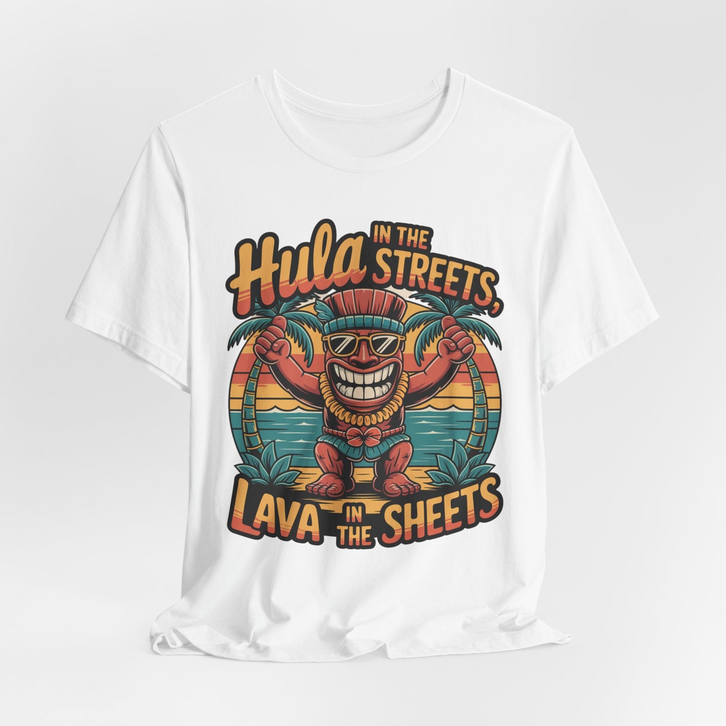 The Hula in the Streets Short Sleeve Tiki T-Shirt features a cartoon tiki with sunglasses and headdress, palm trees, and a sunset. Perfect for summer celebrations, it boasts: Hula in the streets, Lava in the sheets.