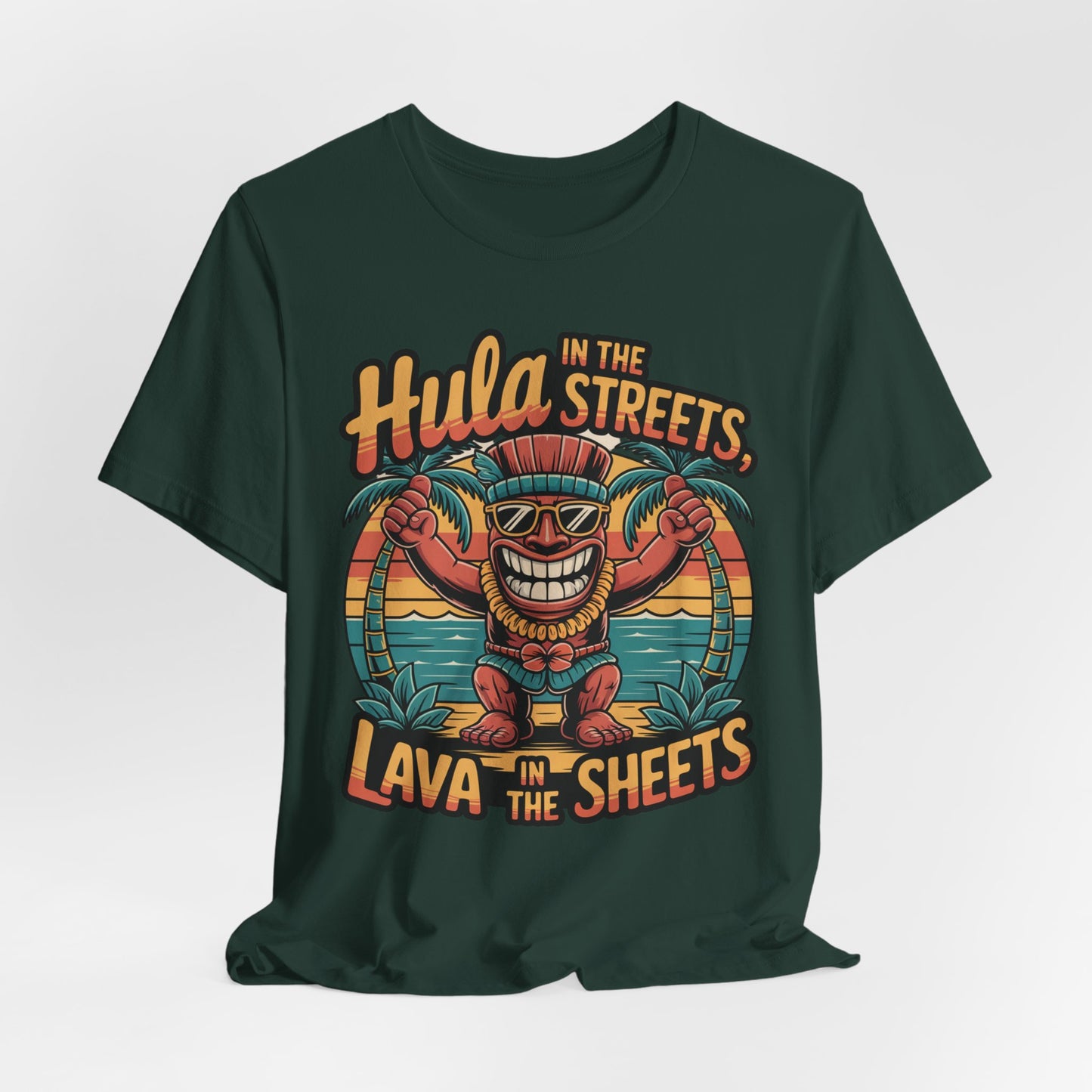 The Hula in the Streets Short Sleeve Tiki T-Shirt is a dark green unisex tee with a vibrant cartoon tiki wearing sunglasses, a hula skirt, and leis between palm trees. Features the text: “Hula in the streets, lava in the sheets.” Perfect for summer celebrations!.