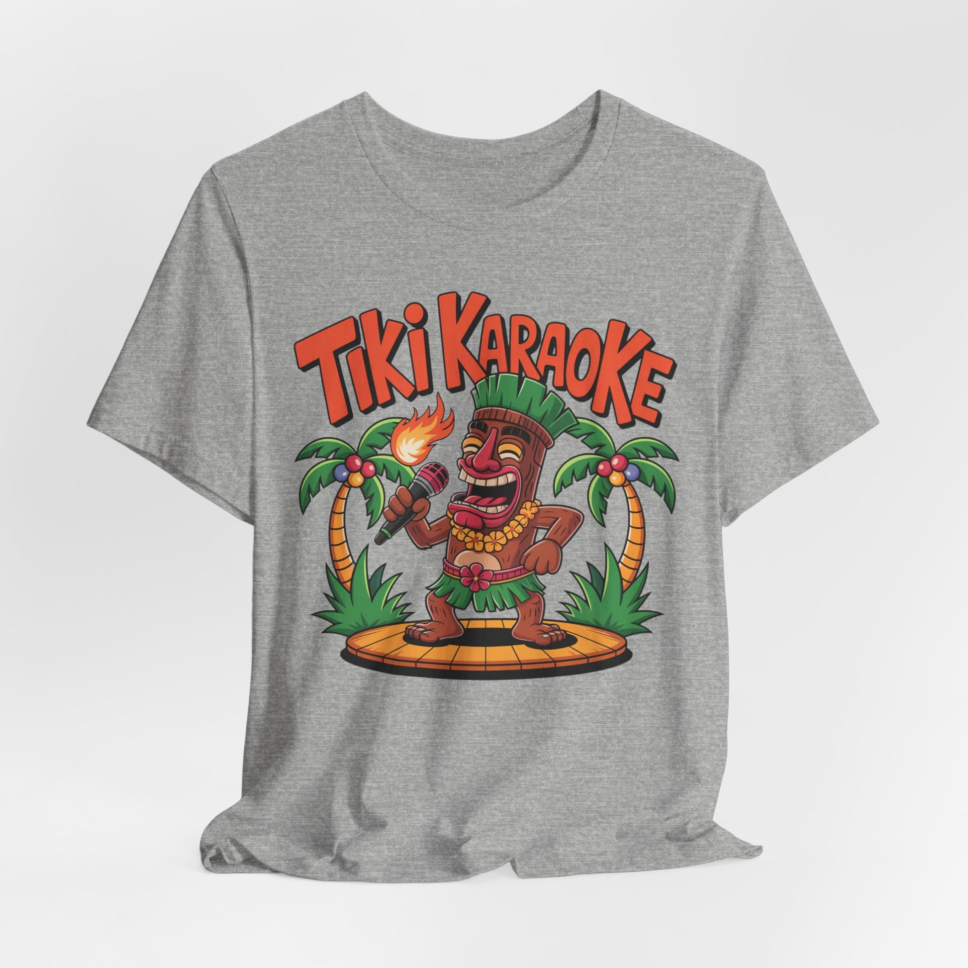 The Tiki Karaoke Unisex Short Sleeve Tiki T-Shirt showcases a colorful cartoon tiki with a flaming torch, palm trees, and bold red “Tiki Karaoke” letters—perfect for a fun summer vibe.