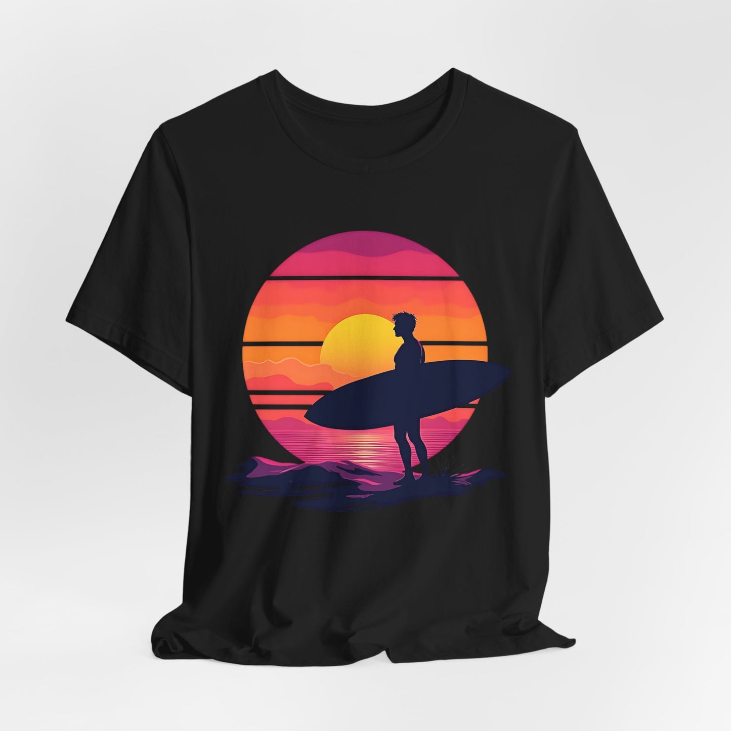 The Sunset Surfing Unisex Jersey T-Shirt features a vibrant graphic of a surfer with a surfboard at sunset in bold yellow, orange, pink, and purple—brought to life with premium DTG printing. Perfect for beach lovers.