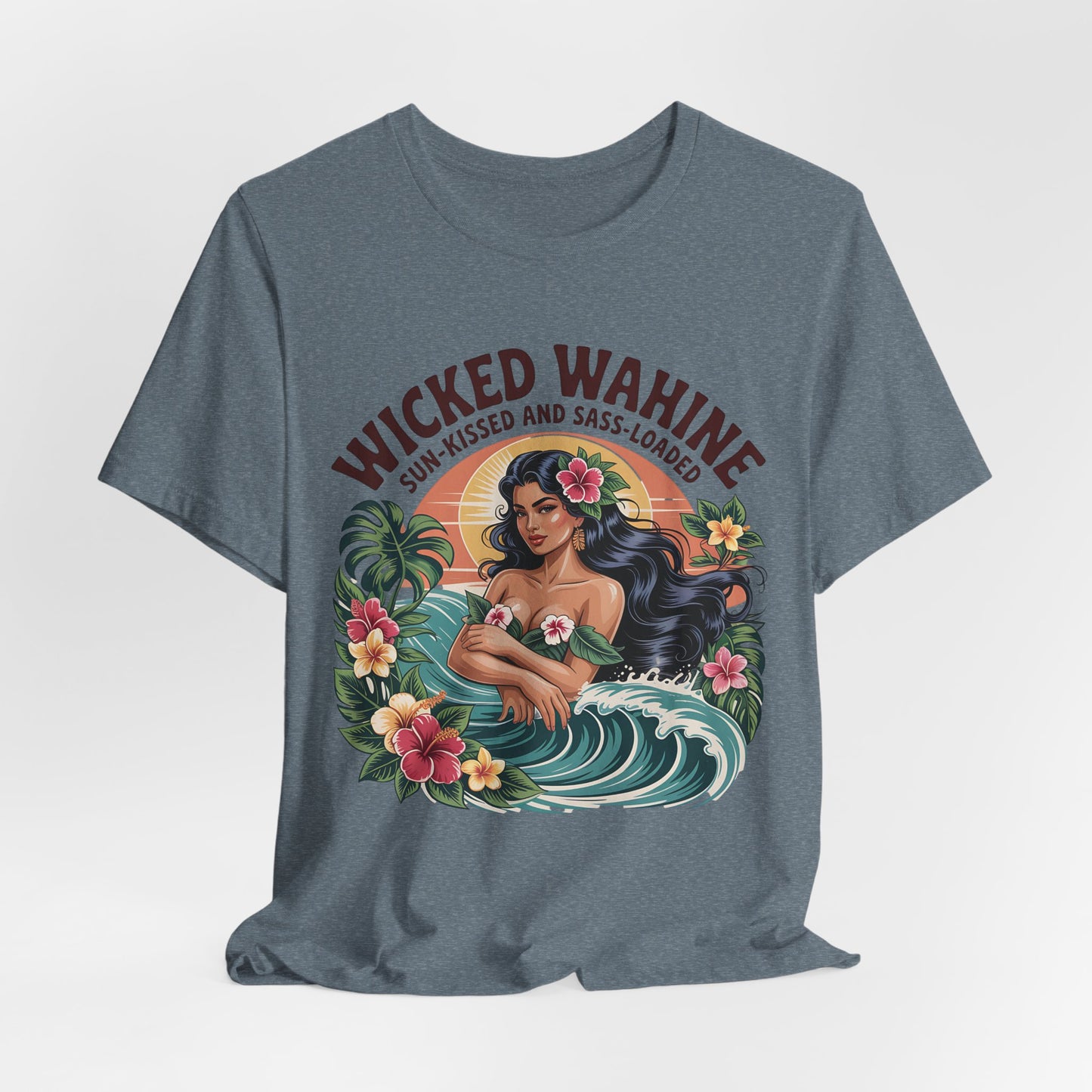 The Wicked Wahine Graphic T-Shirt – Sun-Kissed and Sass-Laden Unisex Jersey features a blue tee with a woman with long dark hair, flowers, tropical designs, and wave. Text: “WICKED WAHINE” above and “SUN-KISSED AND SASS-LOADED” below.