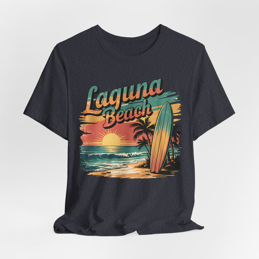 The Laguna Beach Surf Tee - Unisex Jersey Short Sleeve Shirt features a vibrant sunset, ocean, palm trees, surfboard, and bold “Laguna Beach” text—ideal for beach lovers and fans of coastal style.
