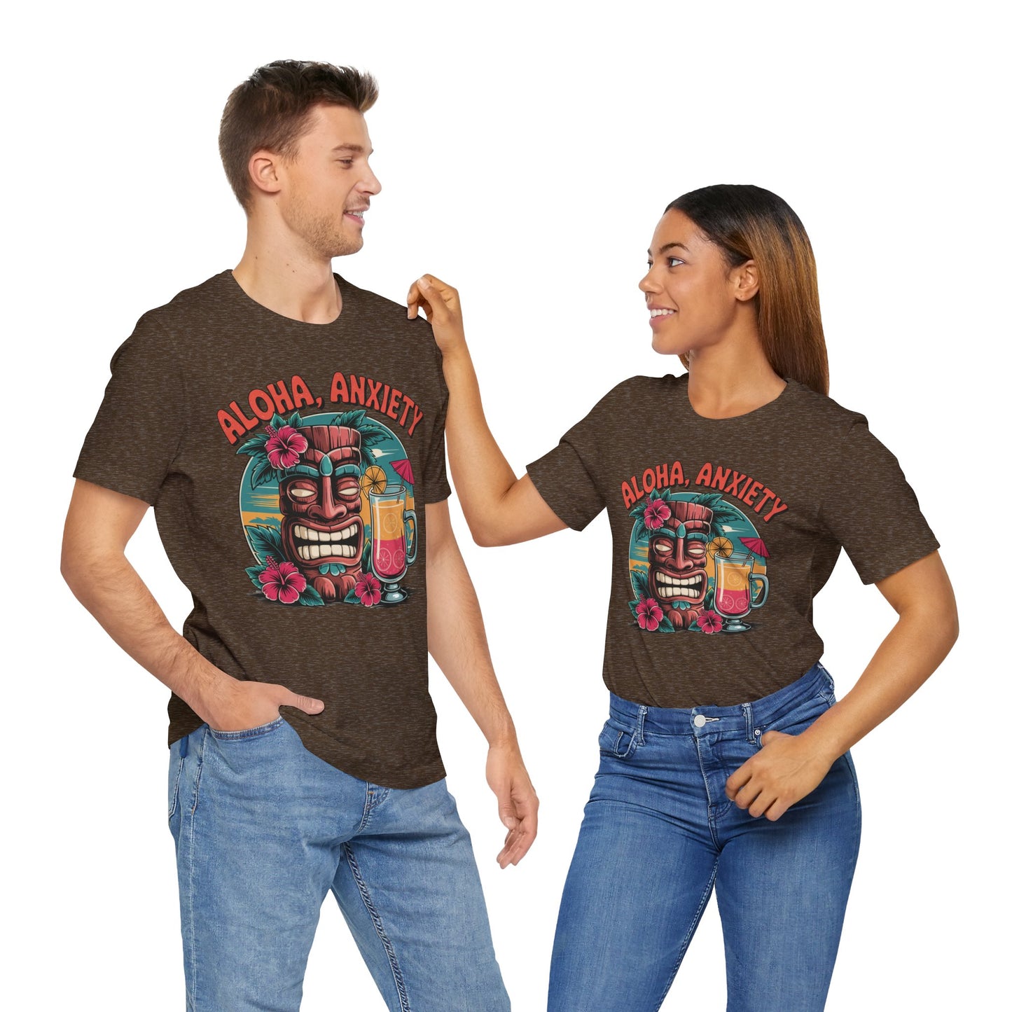 A man and woman smile at each other, both wearing the Aloha Anxiety Unisex Short Sleeve Tiki T-Shirt—made from soft Airlume cotton and featuring tropical flowers, drinks, and Aloha Anxiety on the front for a relaxed island vibe.