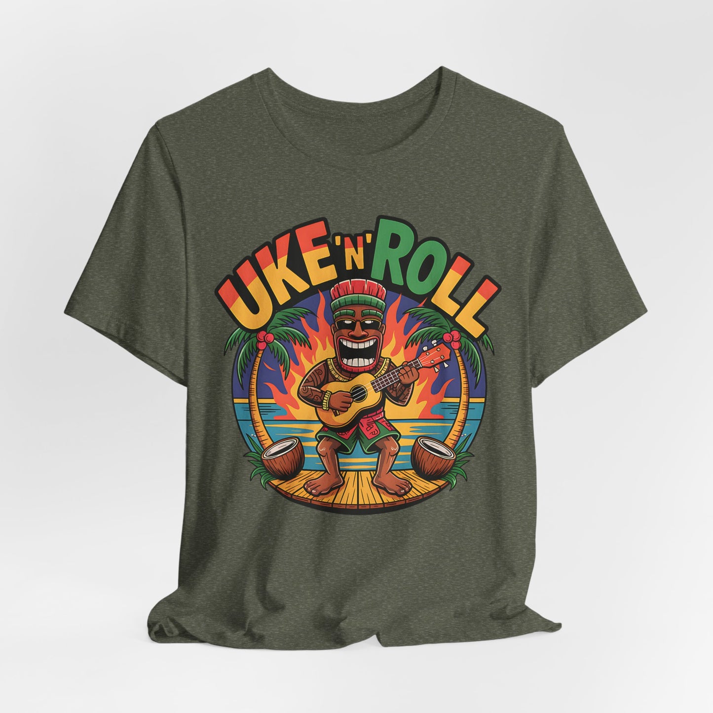 The Uke n Roll Unisex Jersey Tiki T-Shirt features a vibrant cartoon tiki playing ukulele on a beach at sunset with palm trees—perfect for music lovers and beach fans. “Uke N Roll” is printed above for extra fun vibes.