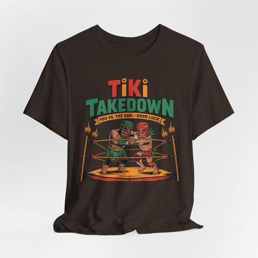 The Tiki Takedown Unisex Jersey Tiki T-Shirt features two tiki figures boxing in a ring, with “Tiki Takedown” above and “You vs. The Bar – Good Luck” below, printed on ultra-soft Airlume cotton for bar lovers.