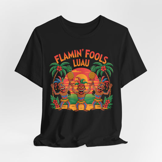 The Flamin Fools Luau Tiki T-Shirt is a black unisex jersey tee with a vibrant design of dancing tiki figures, pineapples, palm trees, and a sunset, plus FLAMIN FOOLS LUAU above the scene—perfect for beach parties.
