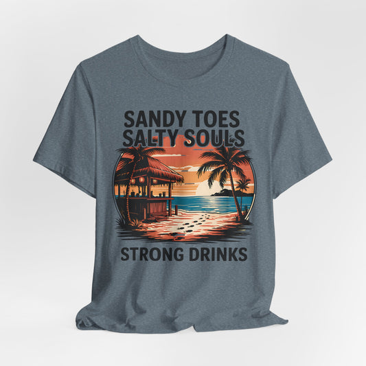 The Sandy Toes Salty Souls Tee - Unisex Jersey Short Sleeve for Beach Lovers features a tropical sunset with palm trees, hut, and ocean. Made from soft Airlume cotton. Reads: Sandy toes, salty souls, strong drinks.