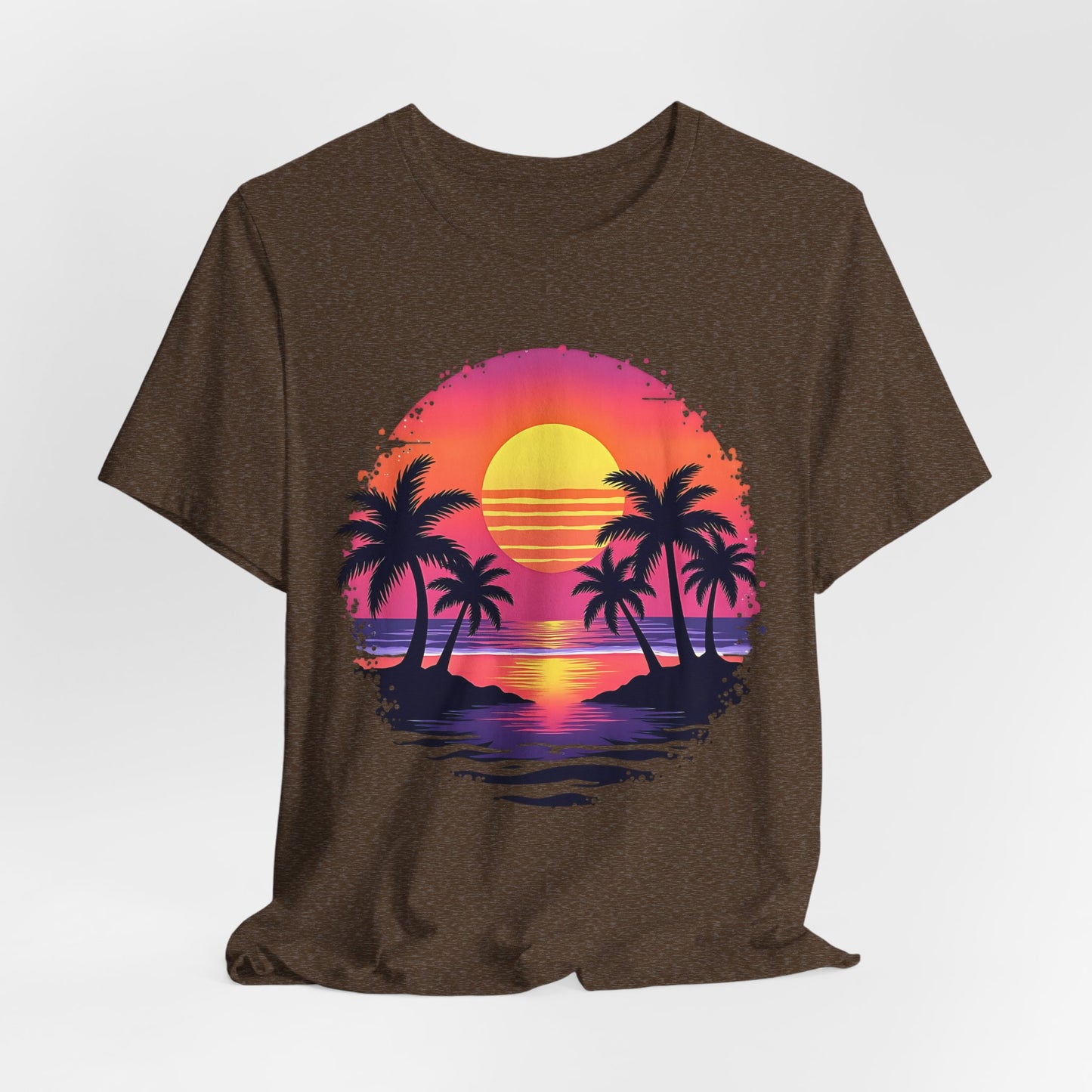 The Tropical Sunset Graphic T-Shirt is a unisex jersey short sleeve shirt made from soft Airlume cotton, featuring a colorful sunset, palm tree silhouettes, and ocean waves—ideal for summer vibes and adding a beachy touch to any outfit.