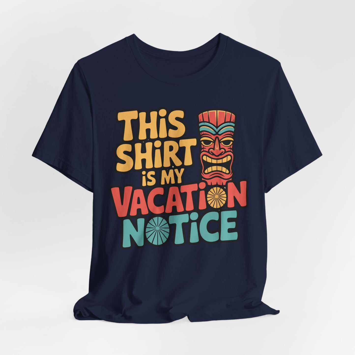 The Tiki T-Shirt - This Shirt is My Vacation Notice Funny Travel T-Shirt features a navy blue unisex jersey with colorful vacation-inspired text and a stylized tiki face beside the word “shirt.”.