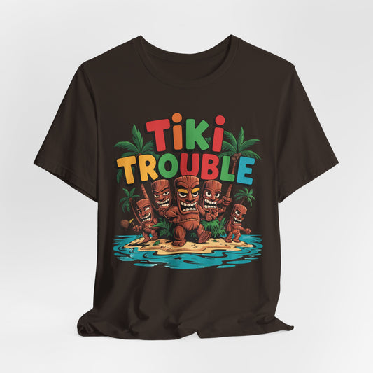 The Tiki Trouble Unisex Tiki T-Shirt showcases vibrant TIKI TROUBLE text and playful tiki statues on an island with palm trees and coconuts—perfect for summer celebrations and fun island vibes.