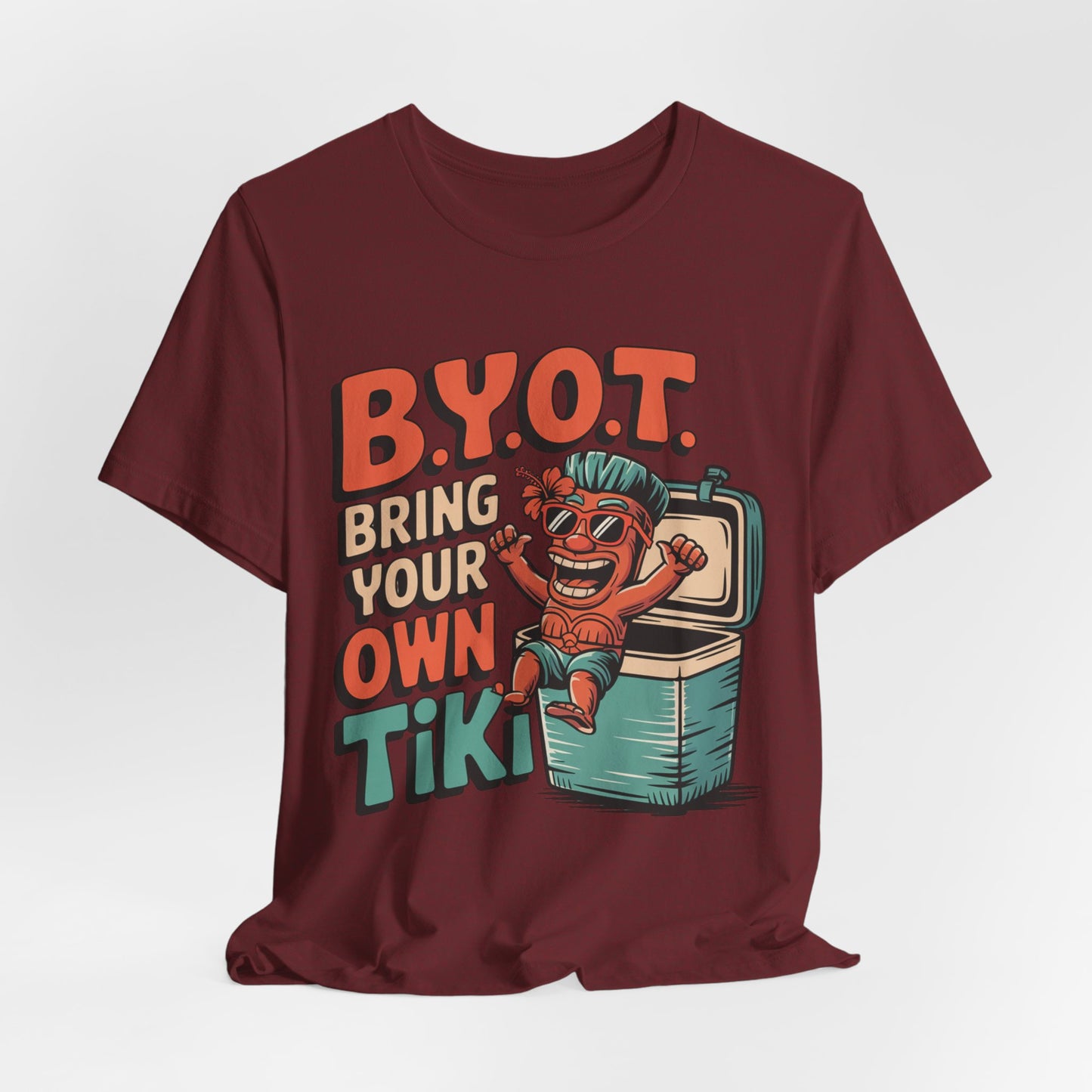 The Bring Your Own Tiki Short Sleeve Tiki T-Shirt is a maroon unisex tee with a cartoon tiki in sunglasses and bold B.Y.O.T. BRING YOUR OWN TIKI text, made from soft Airlume combed cotton—perfect for summer parties.