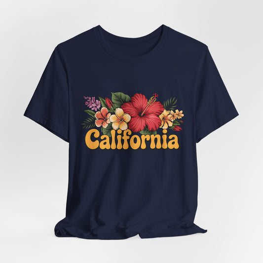 The California Floral Graphic T-Shirt features a vibrant floral design and bold yellow-orange California lettering, offered as a summer vibes unisex short sleeve tee in navy blue.