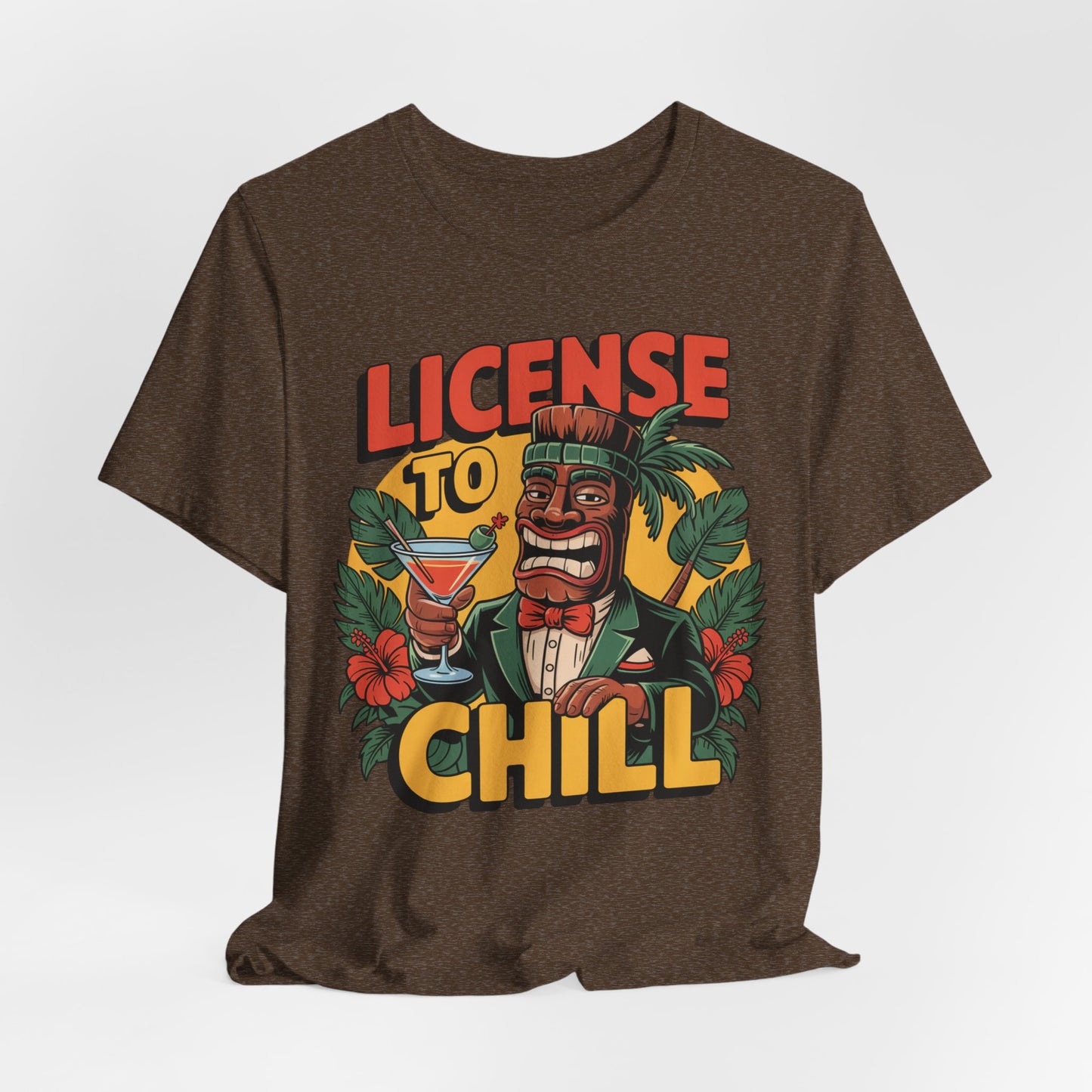 A fun gift for summer BBQs, the License to Chill Tropical Graphic Tiki T-Shirt features a cartoon tiki in a suit with a cocktail, tropical leaves and flowers, and bold LICENSE TO CHILL text in red and yellow.