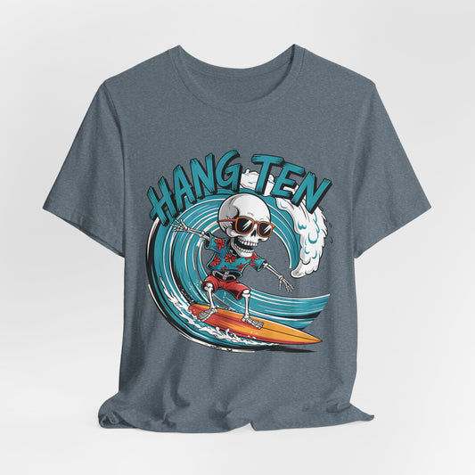 The Surfing Skeleton T-Shirt - Hang Ten Unisex Jersey Tee features a cartoon skeleton in sunglasses and red trunks riding an orange board with “HANG TEN” in bold blue—a perfect beach-themed tee for ocean lovers.