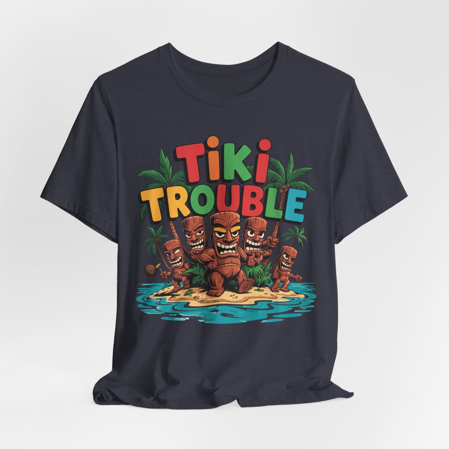 The Tiki Trouble Unisex Tiki T-Shirt showcases vibrant TIKI TROUBLE text above cartoon tiki statues on a tropical island with palm trees and water—perfect for summer celebrations and fun island vibes.