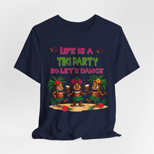 The Tiki Party T-Shirt features three cartoon tiki figures dancing on sand with tropical flowers and the phrase “Life is a Tiki Party so Let’s Dance” in colorful letters—perfect for summer fun!.