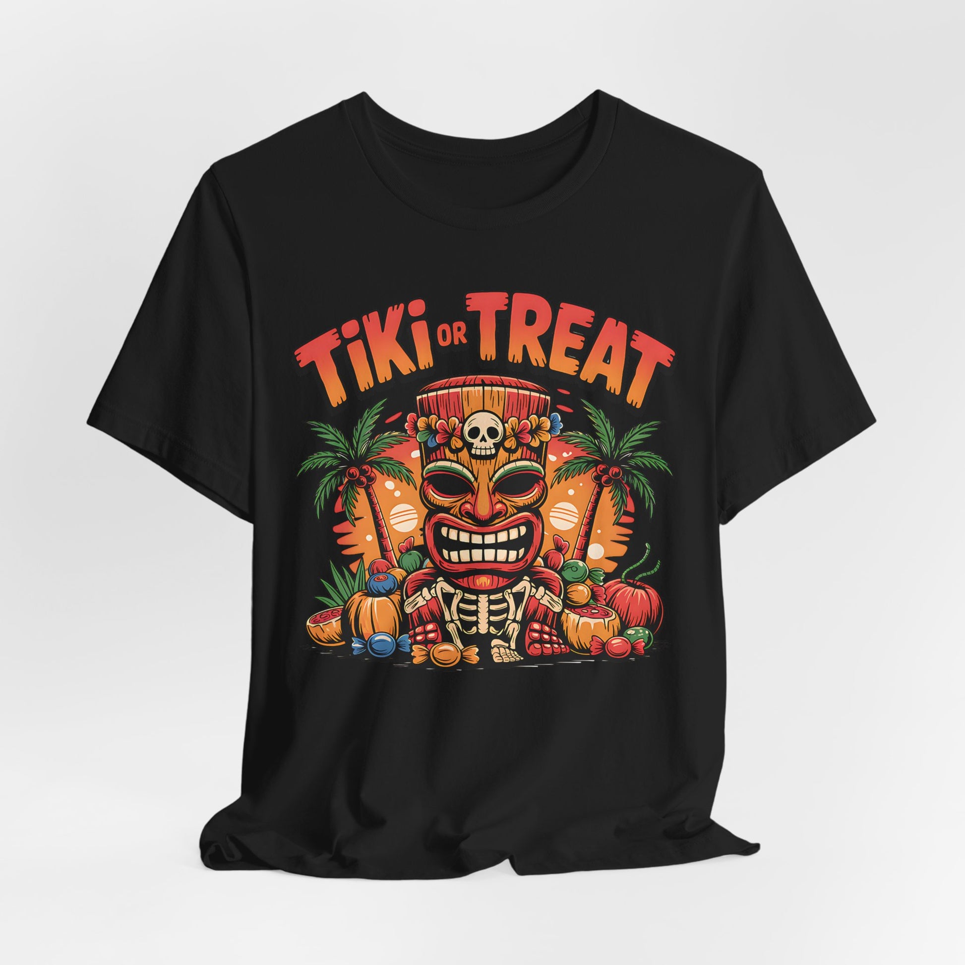 The Tiki or Treat Halloween Tiki T-Shirt is a black unisex jersey tee with a vibrant tiki mask, palm trees, pumpkins, candies graphic, and bold TIKI OR TREAT text in orange and red above the design.